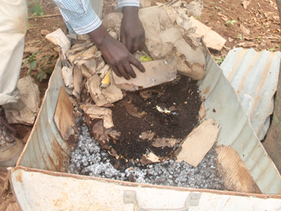 Caleb Omolo showing a container he uses to make organic manure